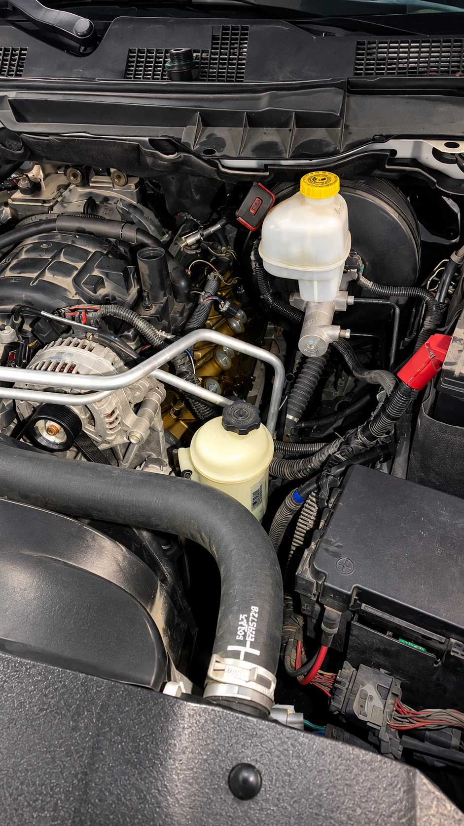 Ram pickup engine bay with the brake master cylinder, power steering reservoir and alternator in view